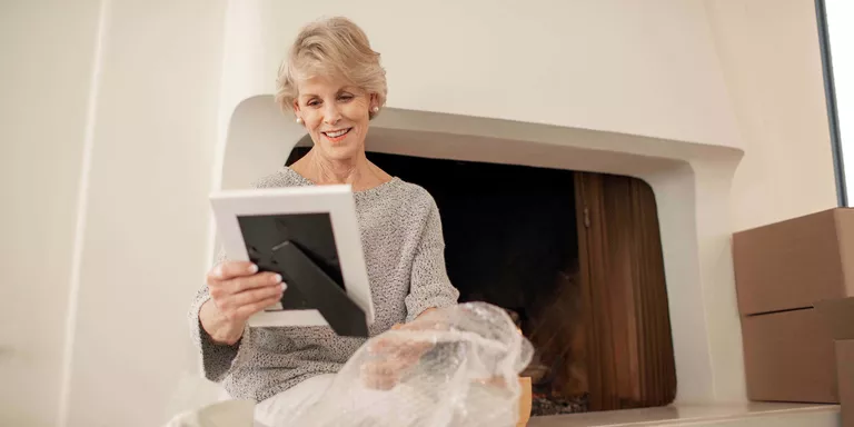 woman unpacking picture frame in new home