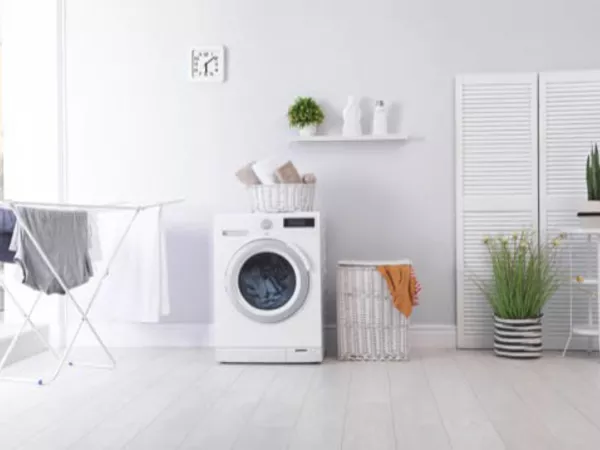 A washer in a clean, white laundry room running its last cycle before a long-distance move.