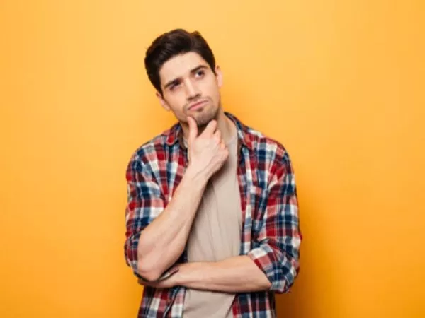 Man with his hand on his chin, considering everything he should know about U-Haul before renting a truck