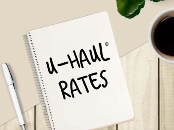 Notepad with &quot;U-Haul Rates&quot; written on it, sitting next to a cup of coffee.