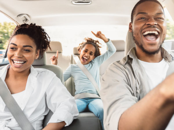 A family rides in their car enjoying a road trip while moving long distance